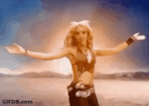 A Woman With Her Arms Outstretched Is Dancing In The Desert . GIF