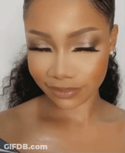 A Woman With Her Eyes Closed And Her Hair In A Ponytail . GIF