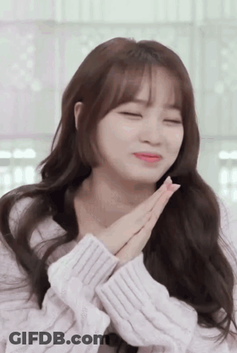 A Woman With Her Eyes Closed And Her Hands Folded In Front Of Her Face GIF