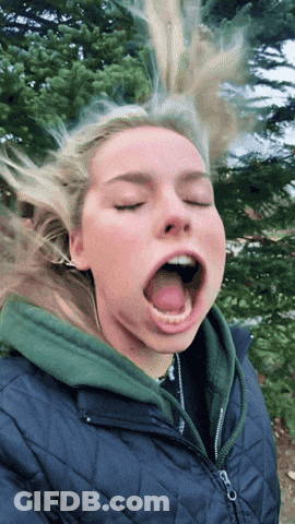 A Woman With Her Eyes Closed And Her Tongue Out GIF