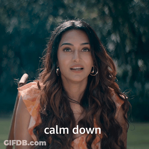 A Woman With Her Eyes Closed And The Words Calm Down Behind Her GIF