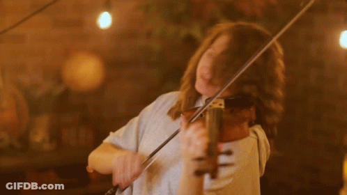 A Woman With Her Eyes Closed Is Playing A Violin GIF