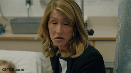 A Woman With Her Eyes Closed Is Sitting In A Hospital Room GIF