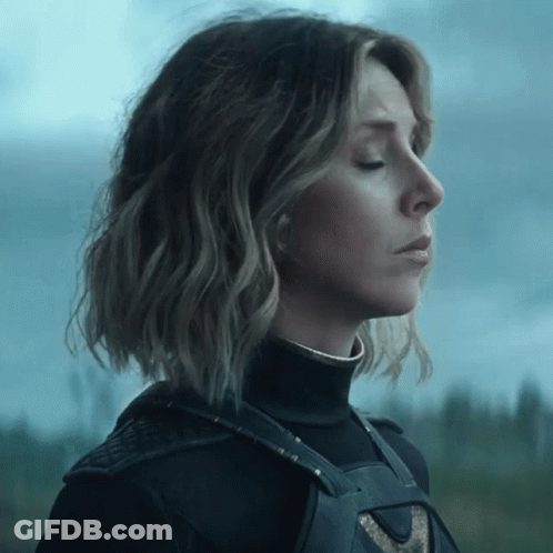 A Woman With Her Eyes Closed Is Wearing A Black Top GIF