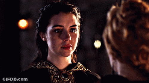 A Woman With Her Eyes Closed Looks Down At Something GIF