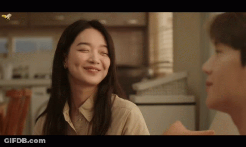 A Woman With Her Eyes Closed Smiles Next To A Man With His Eyes Closed GIF
