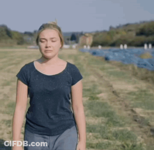 A Woman With Her Eyes Closed Standing In A Field GIF