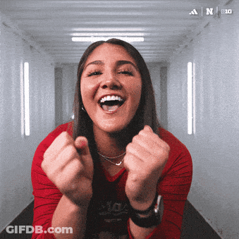 A Woman With Her Fist In The Air Is Wearing A Red Shirt That Says Adidas On It GIF