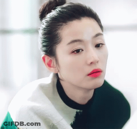 A Woman With Her Hair In A Bun And Red Lipstick GIF