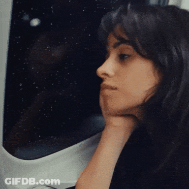 A Woman With Her Hand On Her Chin Looks Out A Window GIF