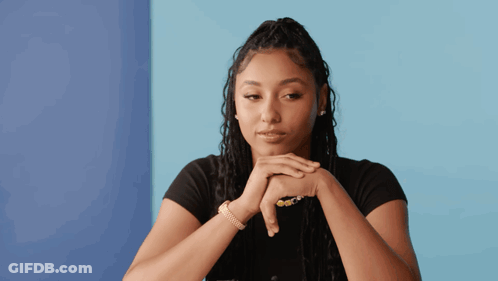 A Woman With Her Hands Folded Against Her Face GIF