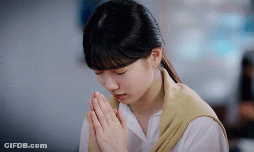 A Woman With Her Hands Folded In Prayer GIF