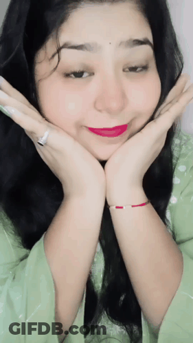 A Woman With Her Hands On Her Face Wearing A Ring And A Bracelet GIF