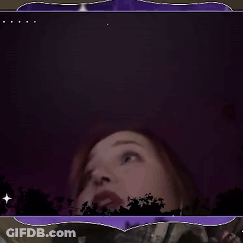 A Woman With Her Mouth Open In A Dark Room GIF
