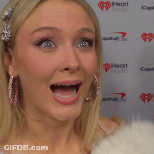 A Woman With Her Mouth Open Stands In Front Of A Wall That Says Capital One GIF