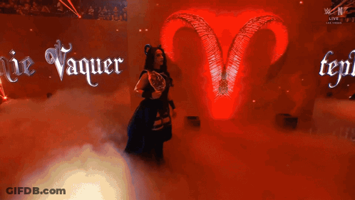 A Woman With Horns And A Trophy In Front Of A Sign That Says Ie Vaquer GIF