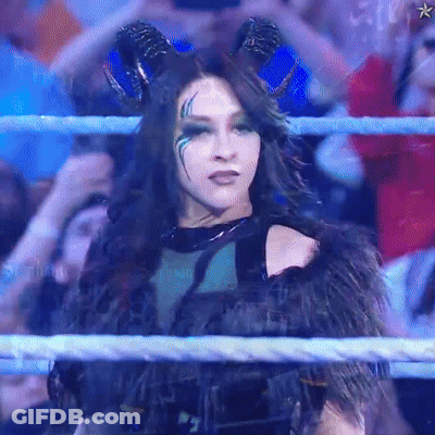 A Woman With Horns Is In A Wrestling Ring With A Crowd Behind Her GIF