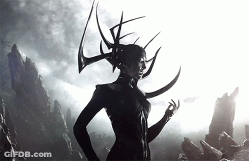 A Woman With Horns On Her Head Stands In Front Of A Mountain GIF