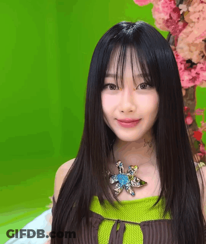 A Woman With Long Black Hair And A Flower Necklace GIF