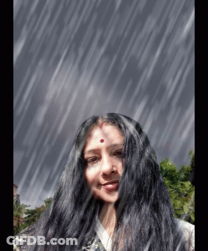 A Woman With Long Black Hair And A Red Dot On Her Forehead Smiles In The Rain GIF