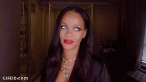 A Woman With Long Black Hair And Red Lipstick Is Wearing A Black Robe And Necklace . GIF