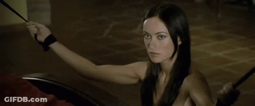 A Woman With Long Black Hair Is Holding A Whip In Her Hand . GIF
