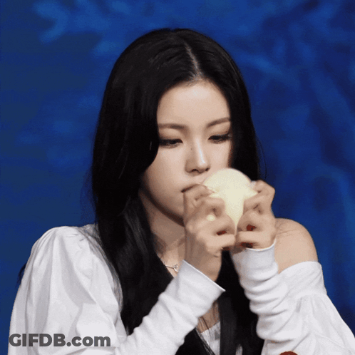 A Woman With Long Black Hair Is Holding A White Object GIF
