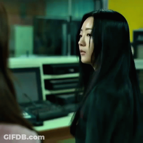 A Woman With Long Black Hair Is Looking At Another Woman GIF