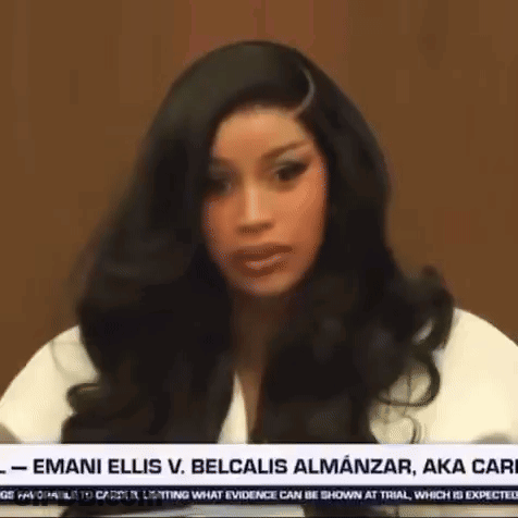 A Woman With Long Black Hair Is Sitting In Front Of A News Anchor . GIF