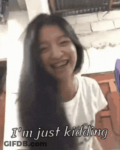 A Woman With Long Black Hair Is Smiling And Says I 'M Just Kidding GIF