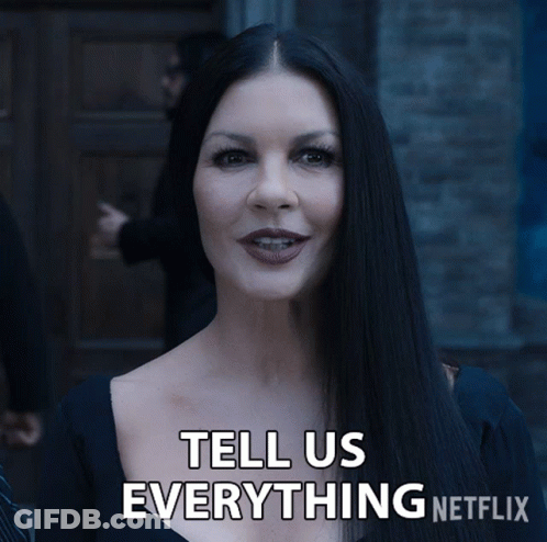 A Woman With Long Black Hair Is Smiling And Says Tell Us Everything Netflix GIF