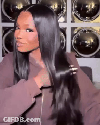 A Woman With Long Black Hair Is Standing In Front Of A Laundry Room . GIF