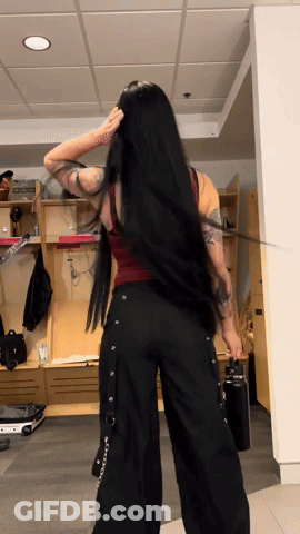 A Woman With Long Black Hair Is Standing In Front Of A Locker That Says Dog On It GIF