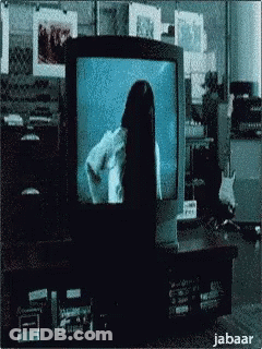 A Woman With Long Black Hair Is Standing In Front Of A Television Screen . GIF
