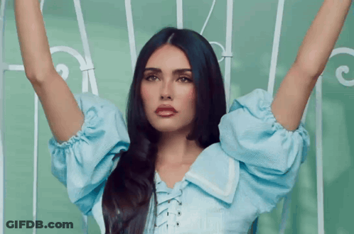 A Woman With Long Black Hair Is Wearing A Blue Shirt And Red Lipstick GIF