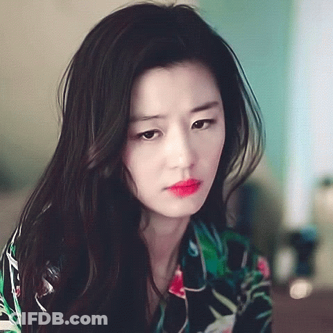 A Woman With Long Black Hair Is Wearing A Floral Shirt GIF