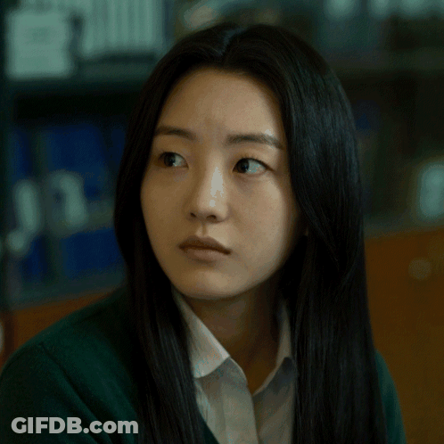 A Woman With Long Black Hair Is Wearing A Green Sweater And White Shirt GIF