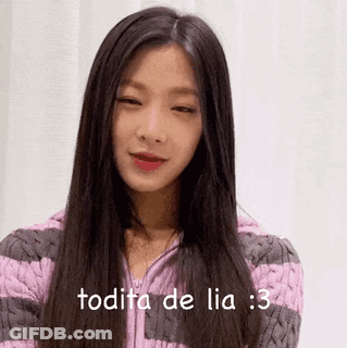 A Woman With Long Black Hair Is Wearing A Pink And Gray Striped Sweater And Says Todita De Lia : 3 . GIF