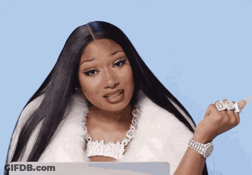 A Woman With Long Black Hair Is Wearing A White Fur Coat And Holding A Laptop . GIF
