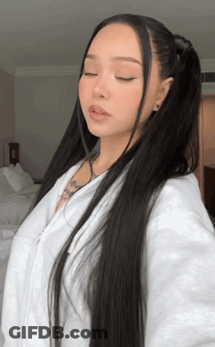 A Woman With Long Black Hair Is Wearing A White Sweatshirt GIF