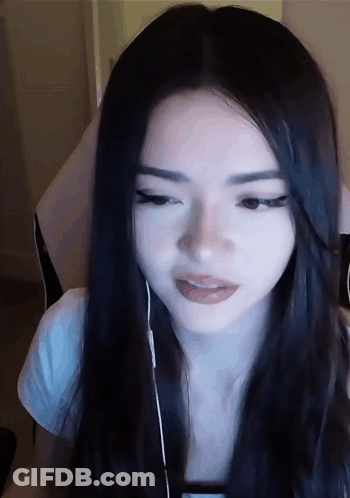 A Woman With Long Black Hair Is Wearing Headphones And Looking At The Camera GIF