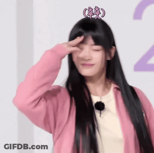 A Woman With Long Black Hair Wearing A Pink Jacket And A Pink Crown On Her Head GIF