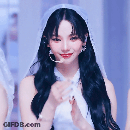 A Woman With Long Black Hair Wearing A White Dress And Veil GIF