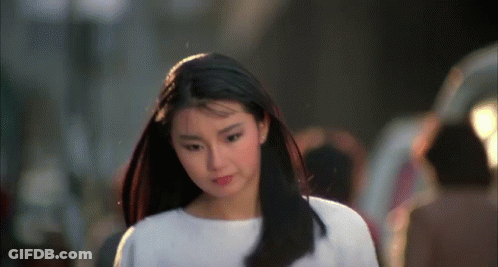 A Woman With Long Black Hair Wearing A White Shirt GIF