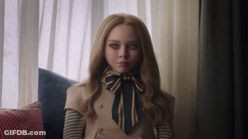 A Woman With Long Blonde Hair And A Bow Tie Is Sitting On A Couch GIF