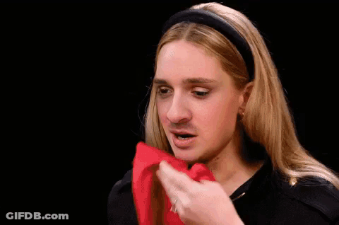 A Woman With Long Blonde Hair And A Headband Is Making A Funny Face And Asking What Do You . GIF