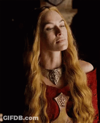 A Woman With Long Blonde Hair And A Necklace Is Wearing A Red Dress . GIF