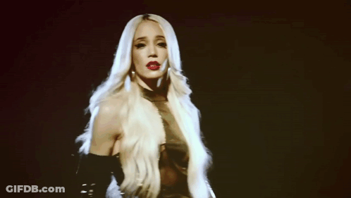 A Woman With Long Blonde Hair And Red Lipstick Is Dancing GIF