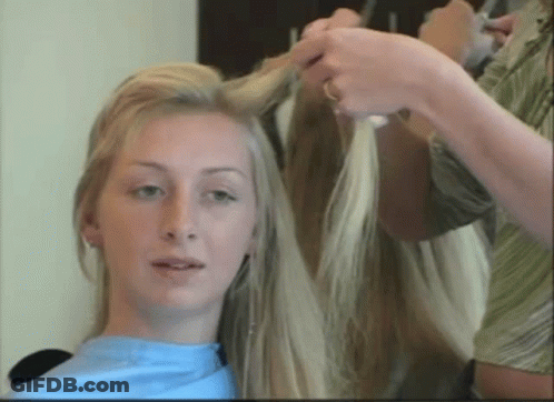 A Woman With Long Blonde Hair Is Getting Her Hair Done GIF