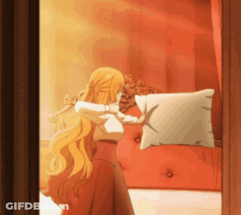 A Woman With Long Blonde Hair Is Holding A Pillow In Front Of A Red Couch GIF